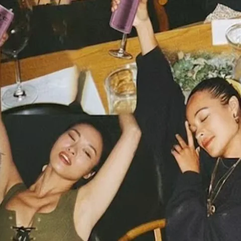 Friends raising Langhua cans at a table